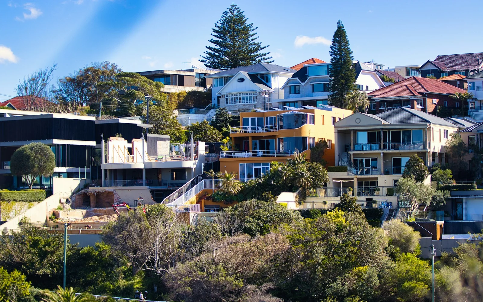Established houses and low-rise apartments on a leafy hillside street